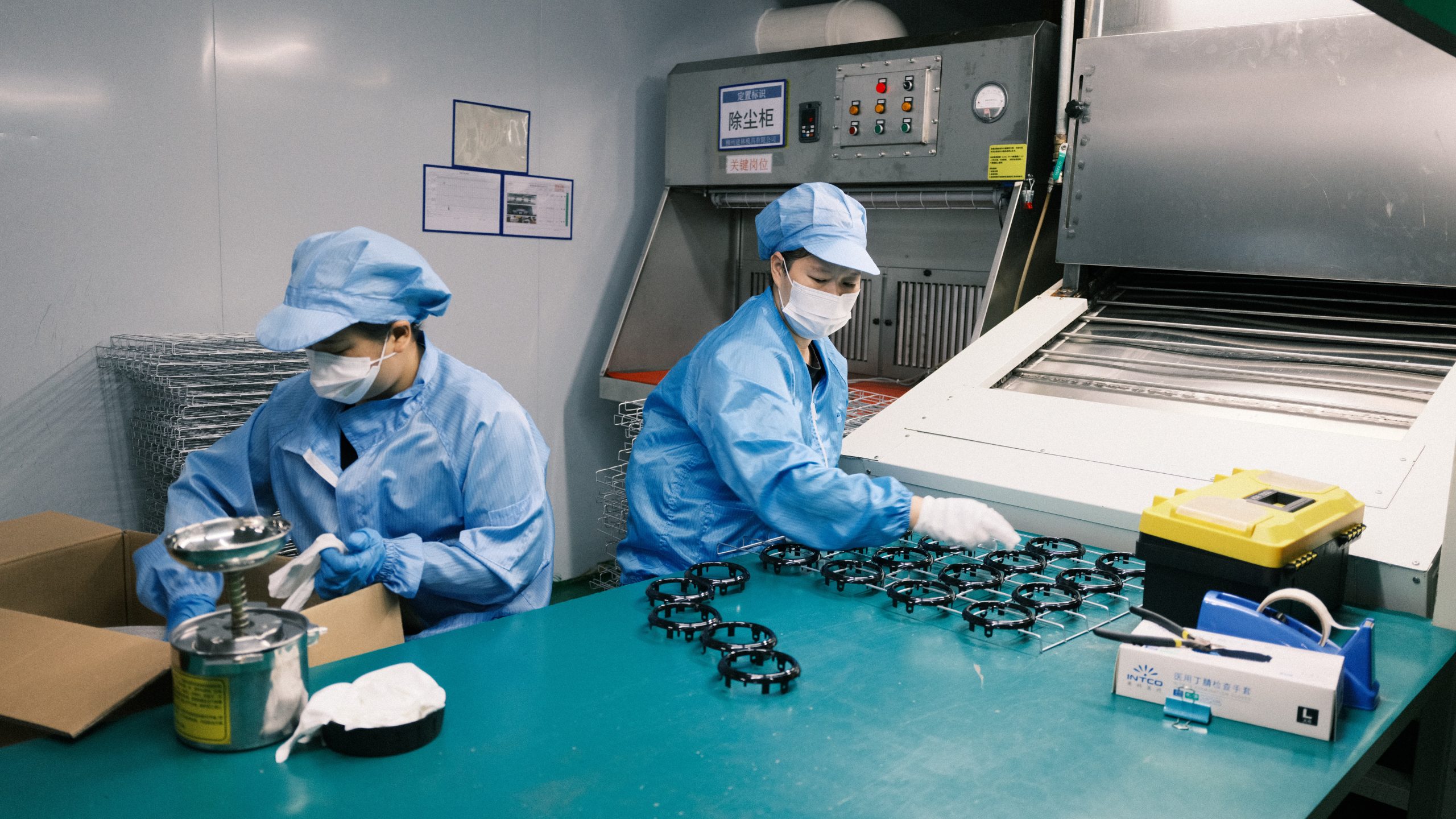 Operators preparing plastic components before the spraying process.