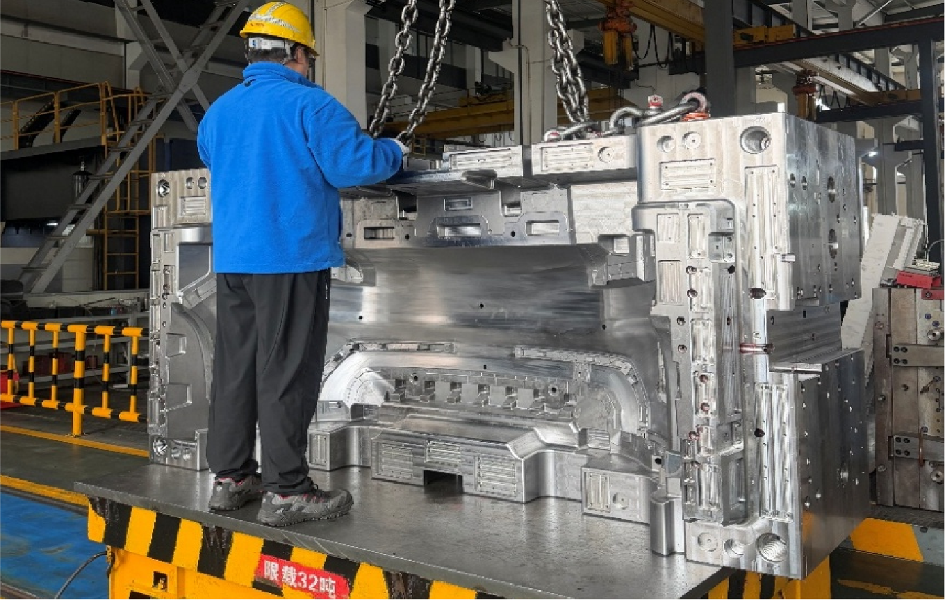 Large-scale automotive mold handling in the workshop.